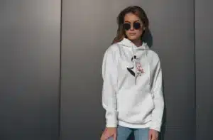 Femme portant un hoodie blanc avec un design artistique féminin, parfait pour une tenue décontractée et stylée.