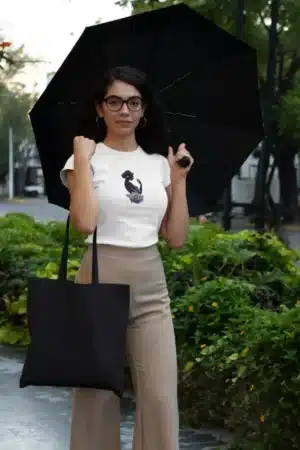 Femme portant un t-shirt blanc avec un dessin artistique de silhouette féminine et une rose violette, parfait pour un look élégant et moderne.