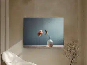 Tableau moderne avec fleur rose dans un vase en verre sur fond bleu.